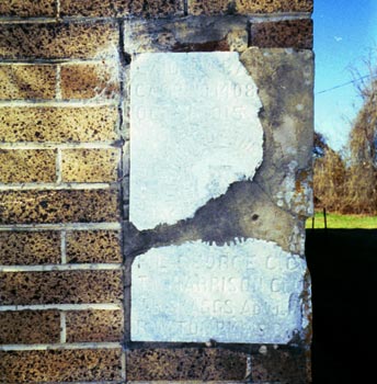 The building's cornerstone, dated Oct. 1, 1915, laid by Camp No. 1408 of the Woodmen of the World. Trustees are listed as J. Taylor, T.N. Harrison and A.F. Schumacher.